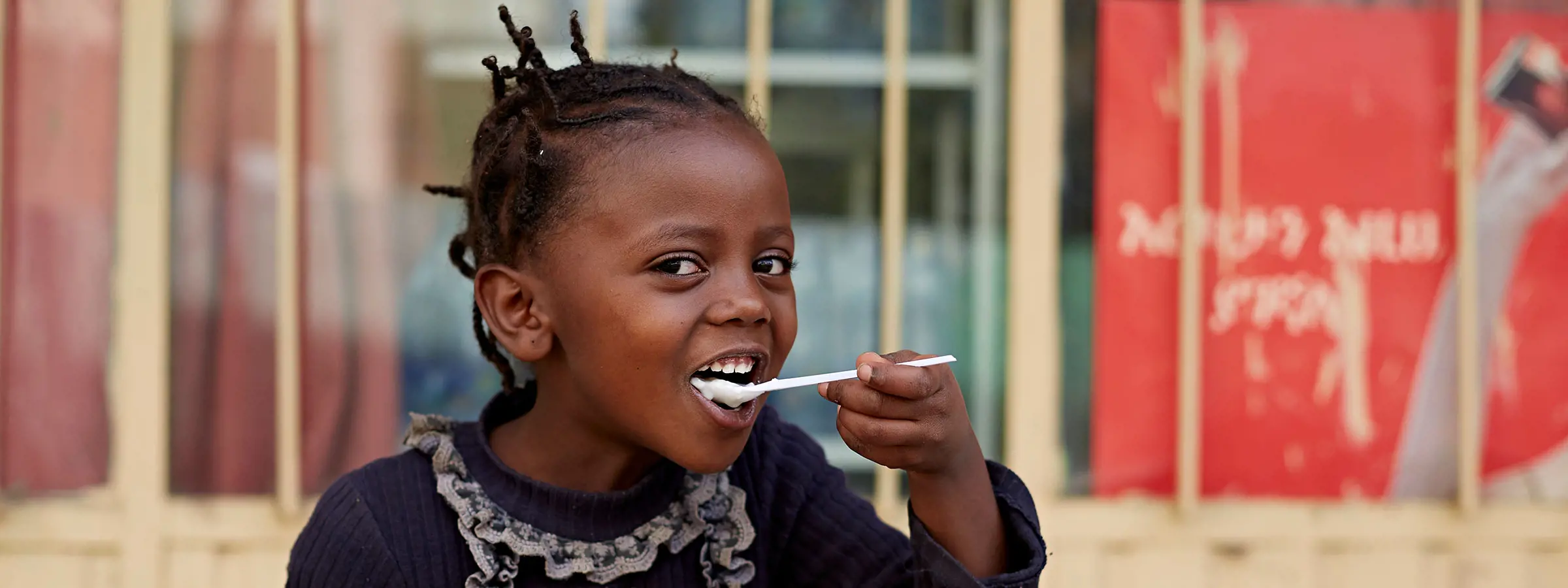 Menina da Etiópia tomando iogurte