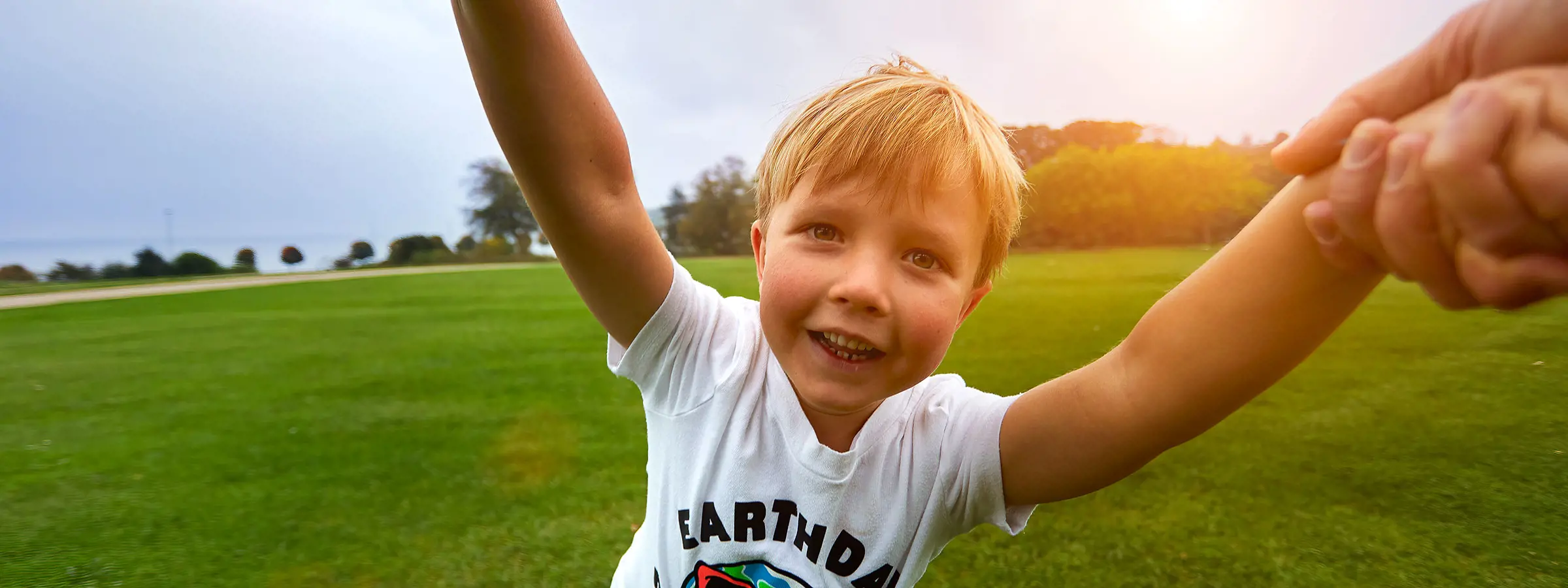 Menino feliz correndo em um campo verde