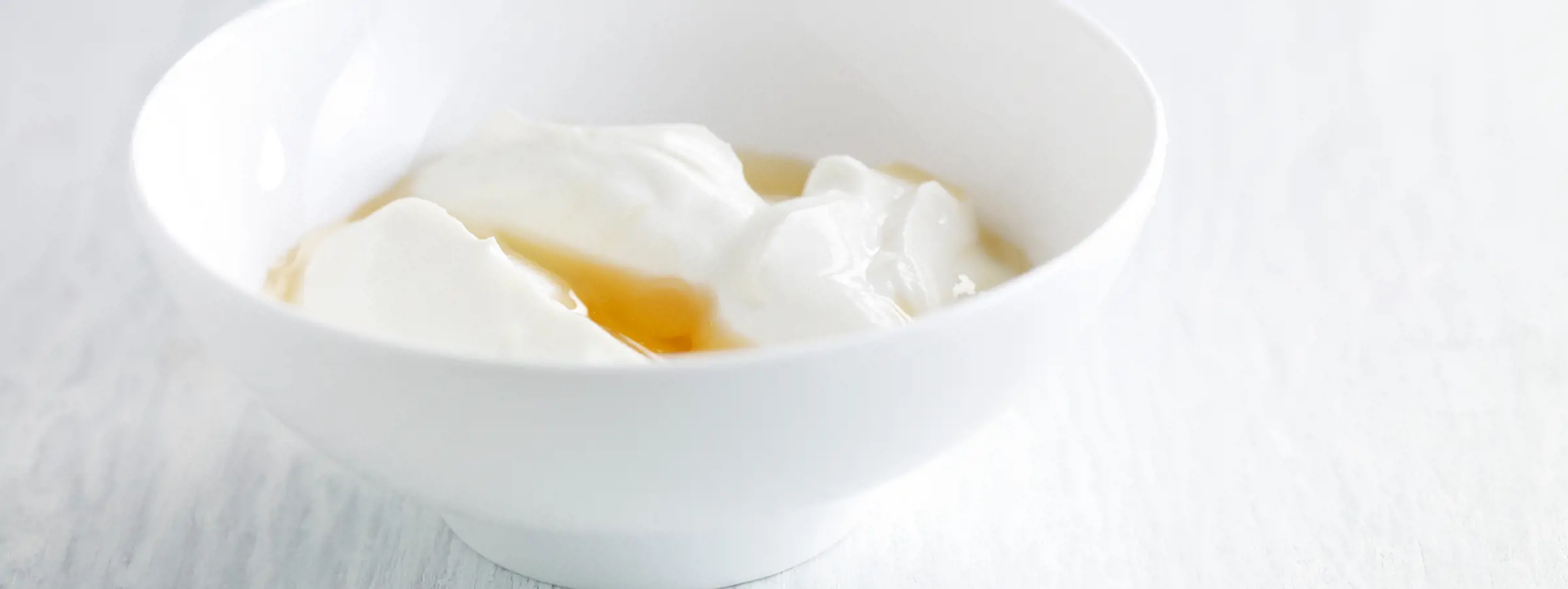 Tigela branca com iogurte grego com mel